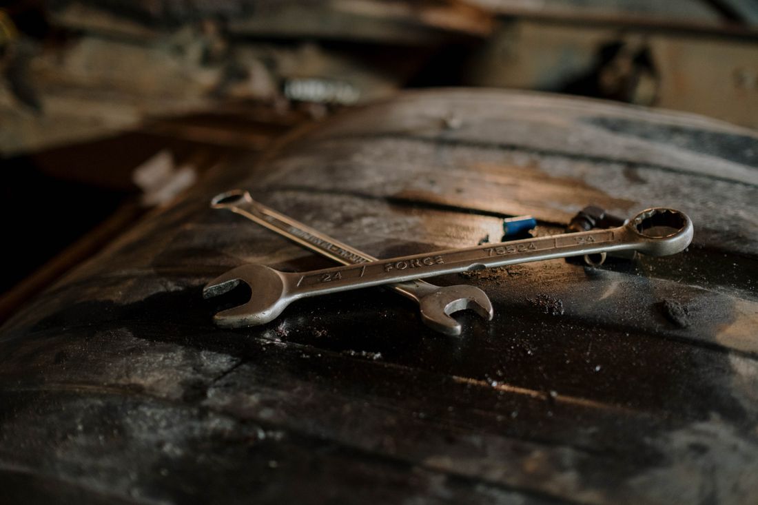 Set of heavy pipe wrenches resting on a worn steel drum
